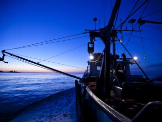 Fishing boat on the water with striking dark blue sky