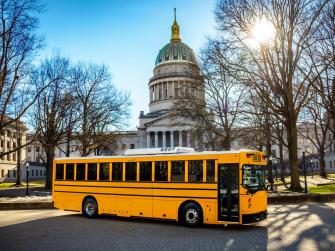 An electric school bus parked in front of the US Capitol