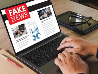 Close up of a person reading fake news on a laptop