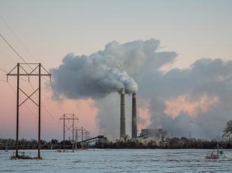 Xcel Energy's Sherburne County (Sherco) Generating Station, a coal-fired power plant, near Becker, Minnesota, shown with snow on the ground and a pink sky.