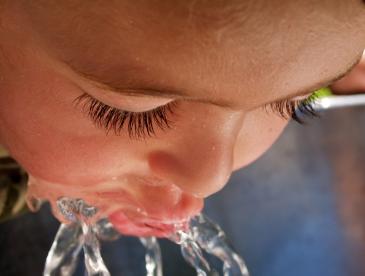 Close view of child drinking from water fountain