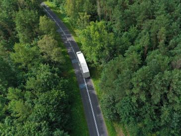 Aerial view of truck on highway through woods