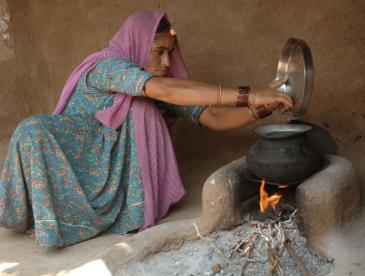 Indian woman using cook stove.