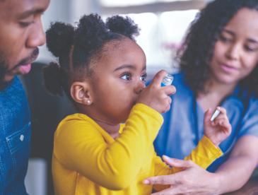 Girl at a doctor's appointment using an asthma inhaler