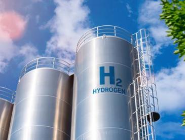 Tall hydrogen storage tanks against a blue sky