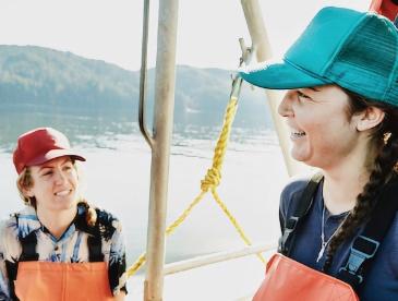 two smiling women fishers on a fishing boat