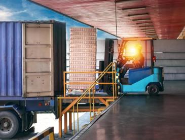 A forklift driver loading or unloading goods onto a truck.