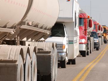 A row of trucks on a crowded road.
