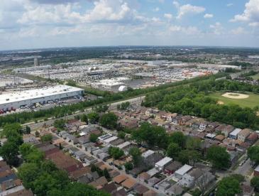 Bird's eye view of residential neighborhood next to a warehouse.