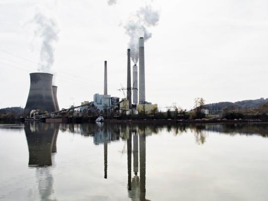 Smoke rises from the smokestacks of an industrial plant.