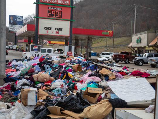 Clothing and debris piled next to a gas station