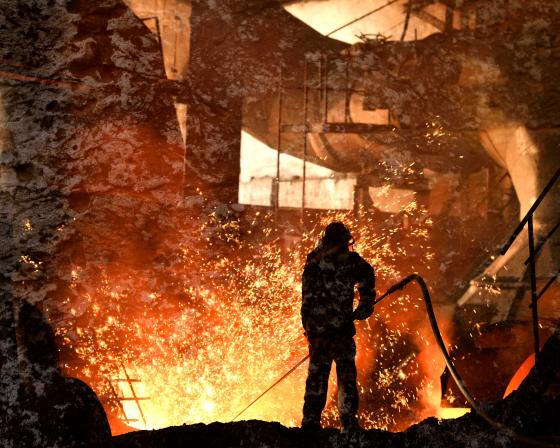 Steelworker working with very hot materials, amidst sparks.