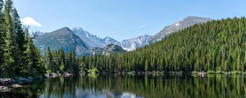 Beautiful mountains and forest by a pool of crystal clear water