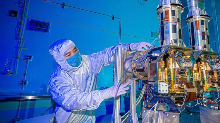 Worker in a lab preparing a component of a satellite