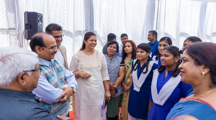 A group of about a dozen people talking and celebrating at an event in Indore, India.